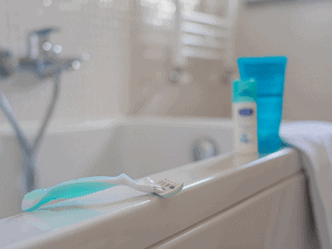 Razor, bottles and towel in a tub