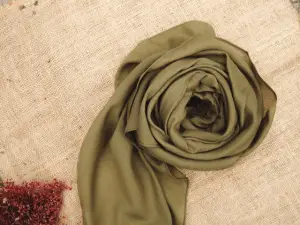 Silk scarf placed near flowers on table