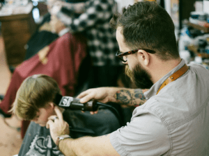 young man getting hair cut with clippers
