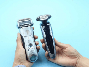 two hands holding electric shavers