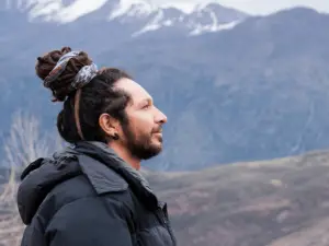 young man with dreadlocks and jacket in a mountain