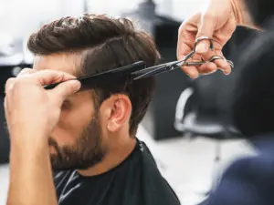 man getting a haircut in a shop