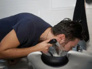 man washing his beard with water