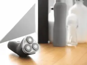 electric shaver beside bottles on a table