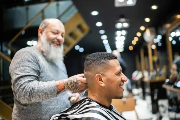 hairdresser-cutting-the-hair-of-a-young-man-at-the-barber-shop